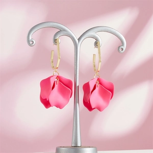 Vintage gold geometric earrings with pink petal drops displayed on a silver stand
