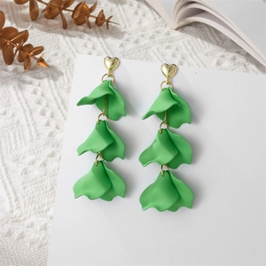 Detail view of long petal earrings featuring green matte layers and a golden heart stud