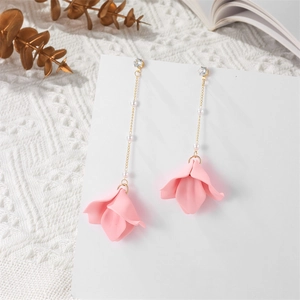 Detail of elegant long tassel earrings with white pearls and matte pink floral petals