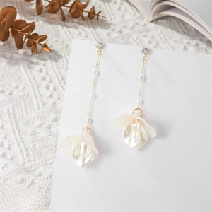 Detail of elegant pearl chain earrings with white petal drops and gold finish