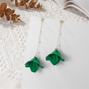 Detail of long pearl chain earrings with dark green flower petals on a white display