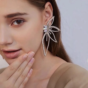 Dramatic oversized butterfly drop earrings featuring shimmering crystals and opal-like accents