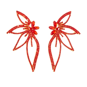 Exaggerated golden butterfly earrings with vibrant red rhinestones on white background