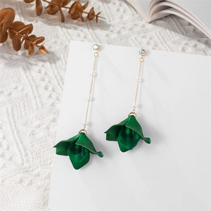 Detail of elegant emerald green petal tassel earrings with gold chains and pearls