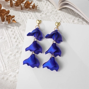 Close-up of royal blue triple-layered petal drop earrings with gold heart stud