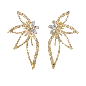 Detailed close-up of asymmetrical gold leaf earrings with sparkling micro-pave diamonds