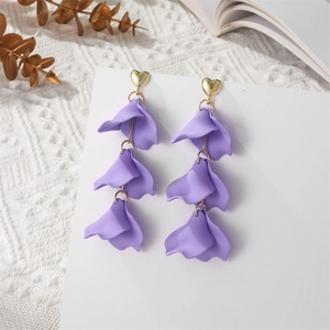 Detail of lavender petal drop earrings with gold heart studs on a clean white background