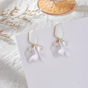 Close-up of matte white flower petal drop earrings with enamel finish and iridescent beads
