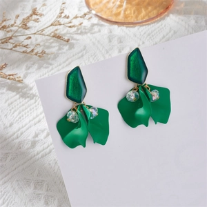 Close-up of matte green flower petal earrings with faceted beads on lace background