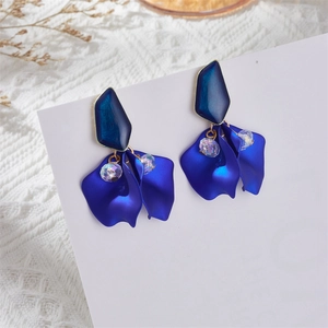 Close-up of blue petal drop earrings with matte finish and iridescent bead on white lace