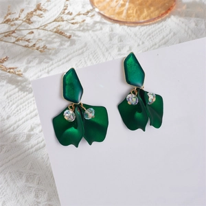 Macro detail of dark green matte petal earrings with elegant faceted crystal beads