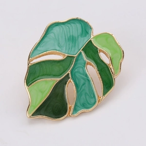 Detailed close-up of monstera leaf earring with vibrant green enamel and gold plated edges