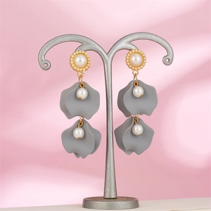 Detail of vintage gray petal drop earrings with white pearls on a metallic stand