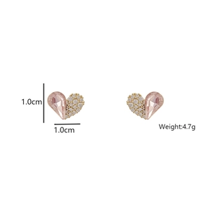 Detail showing asymmetric heart stud earrings with pink crystal and white pavé stones