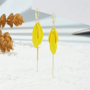 Detail of long tassel earrings featuring yellow petal charms and delicate gold chains