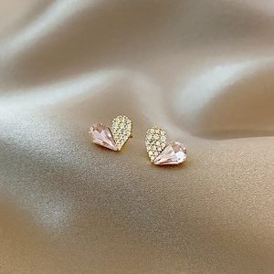 Detailed close-up of heart stud earrings with pink crystal and pavé white zircon stones
