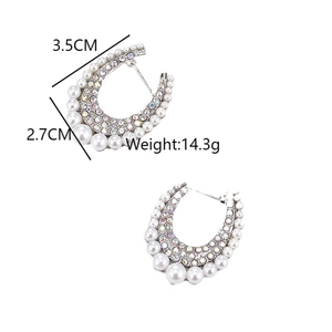 Detail of silver crescent earrings featuring white pearls and iridescent rhinestones