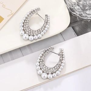U-shaped earrings with graduated pearls and pave rhinestones in polished silver setting