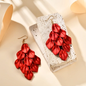 Exaggerated red petal tassel earrings with matte finish and gold-tone hooks on stone