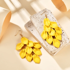 Artistic detail of bright yellow layered petal drop earrings with golden hooks