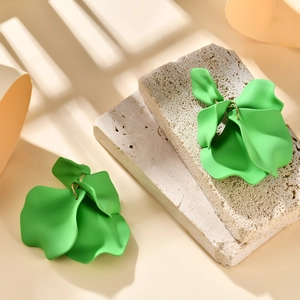 Macro detail of matte fruit green floral petal earrings with gold metal ring hooks
