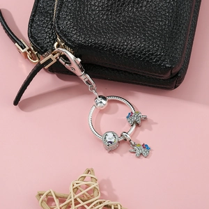 Silberner Einhorn Schlüsselanhänger mit Strass an einer schwarzen Lederhandtasche