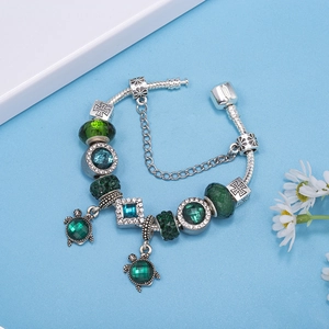 Silver snake chain bracelet with green cat-eye crystal turtle charms and blue beads