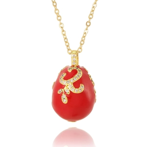 Détail du pendentif œuf en émail rouge avec filigrane doré et pierres en zircon