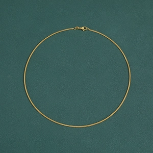Classic gold plated Chopin chain necklace with lobster clasp on dark green background