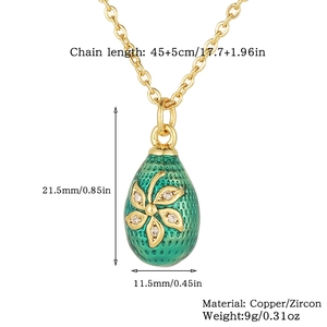Macro shot of green enamel egg pendant with gold floral patterns and zircon stones