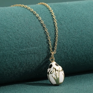 Elegant 18K gold plated necklace with white enamel egg pendant and floral patterns