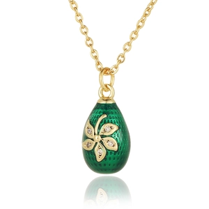 Detailed close-up of a green enamel egg pendant with a gold flower and cubic zirconia stones