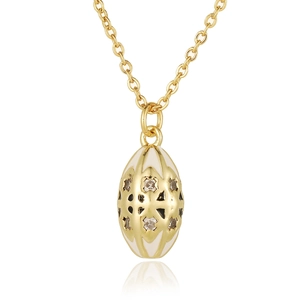Macro detail of gold egg-shaped pendant with white enamel and sparkling crystals