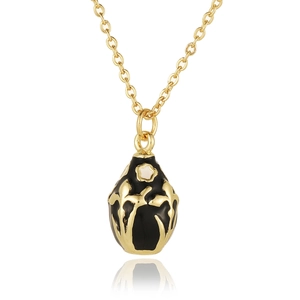 Detail of egg pendant with black enamel, golden floral patterns and tiny white flower