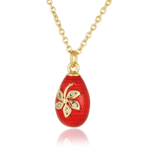 Detailed macro view of red enamel egg pendant with gold flowers and micro-set zircons