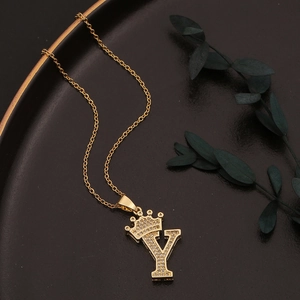 Nahaufnahme von goldenem Kronen-Initial Y Anhänger mit Zirkonia auf schwarzem Display