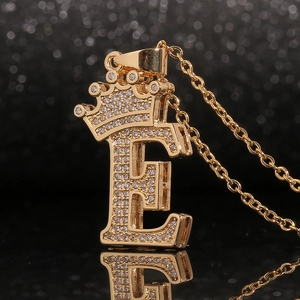 Makro-Detail des goldenen Krone Buchstabe E Anhängers mit weißem Zirkonia-Besatz