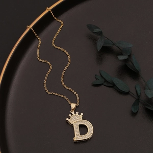 Detailansicht goldener D-Anhänger mit Krone und funkelnden Zirkonia-Steinen auf Kette