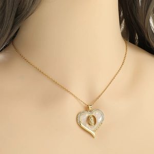 Gold heart pendant necklace with mother of pearl and Virgin Mary relief on model