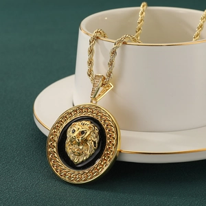 Collier à pendentif tête de lion dorée avec émail noir et cristaux sur une chaîne torsadée