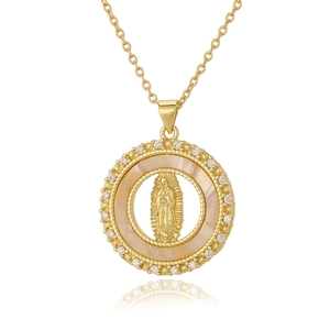 Macro detail of gold Virgin Mary pendant with sparkling crystals and mother of pearl