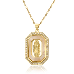Detailed macro view of octagonal Virgin Mary pendant in gold with white crystal border