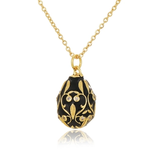 Macro shot of Fabergé-style egg pendant with black enamel and gold vine patterns