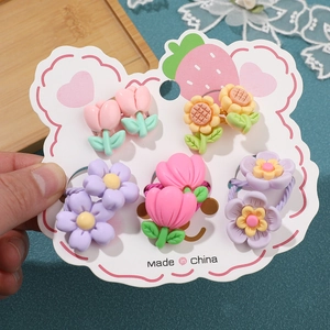 Detail van 10-delige set kleurrijke bloem haarelastiekjes op schattige aardbeienkaart