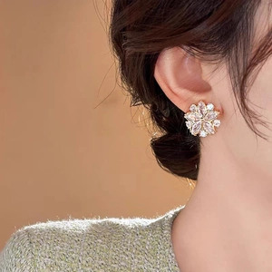 Eleganti orecchini a lobo a fiore dorati con pietre di zirconia marquise su una modella