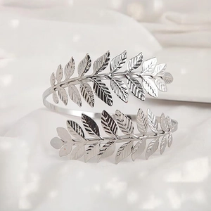 Silver leaf cuff bracelet featuring detailed spiral vine design on white fabric