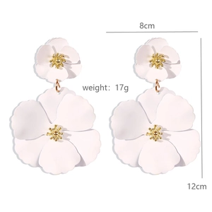 Detail view of large bohemian double layered white flower earrings with gold core accents