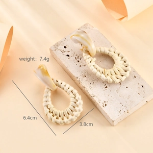 Detail of handmade raffia flower earrings with marble resin studs for a beach look