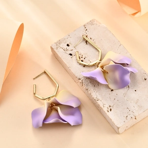 Orecchini a petalo con sfumatura viola e ganci dorati su espositore in pietra estetica