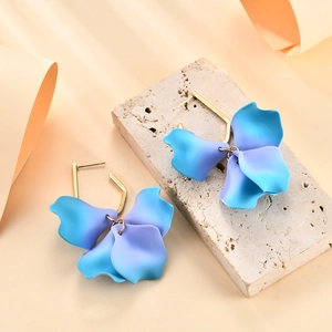 Dettaglio orecchini a petalo con sfumatura blu-viola e cerchi in metallo dorato